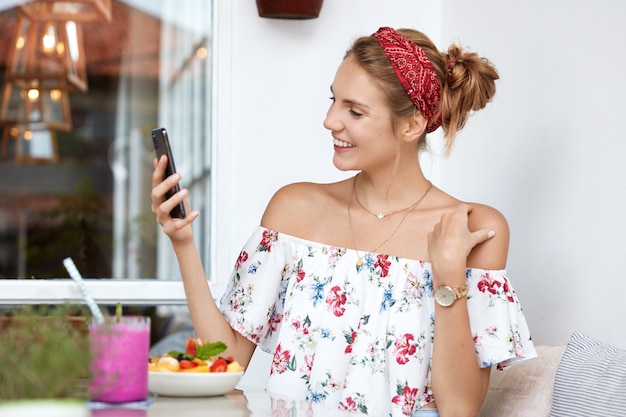 Mulher loira com vestido floral em um café