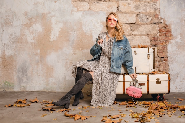 Foto grátis mulher loira elegante e atraente em jeans e jaqueta grande andando contra a parede na rua