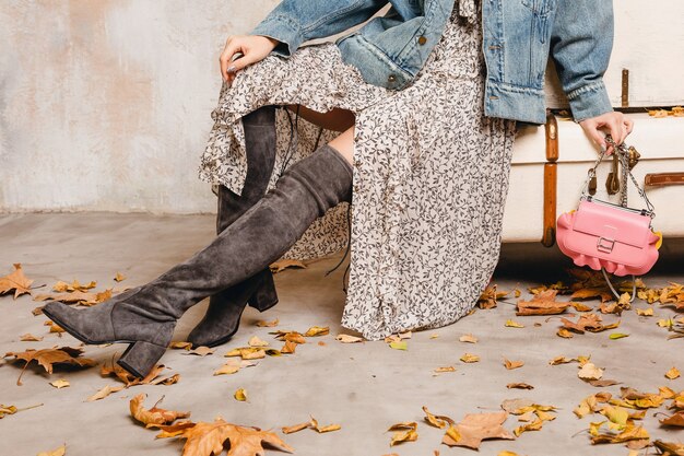 Mulher loira elegante e atraente em jeans e jaqueta grande andando contra a parede na rua