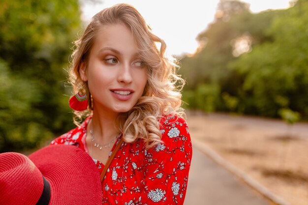 Mulher loira elegante e atraente sorridente com chapéu vermelho palha e blusa roupa da moda de verão