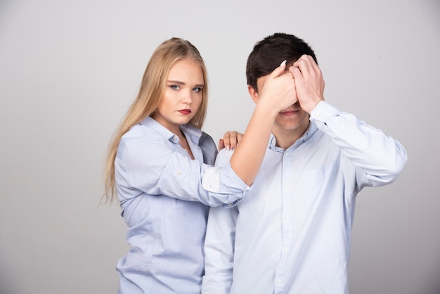 Mulher loira em pé e fechando os olhos para o modelo cara de camiseta branca