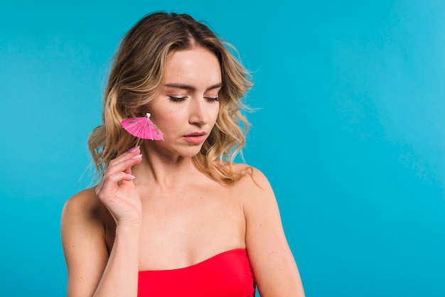 Mulher loira em roupas vermelhas com guarda-chuvas cocktail