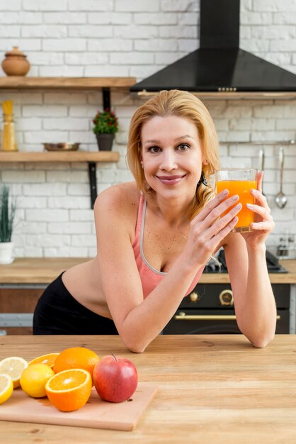 Mulher loira na cozinha com frutas