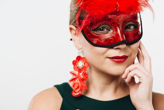 Mulher loira na máscara de carnaval vermelho