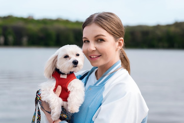 Mulher loira segurando cachorro maltês