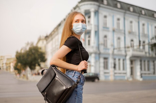 Mulher loira usando máscara médica do lado de fora