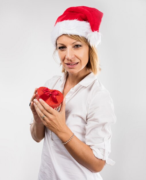 Mulher loura com um presente e um chapéu de Santa