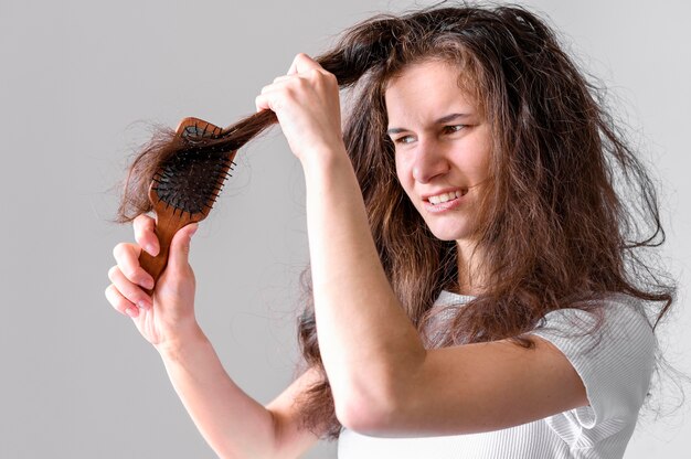 Mulher lutando para escovar o cabelo