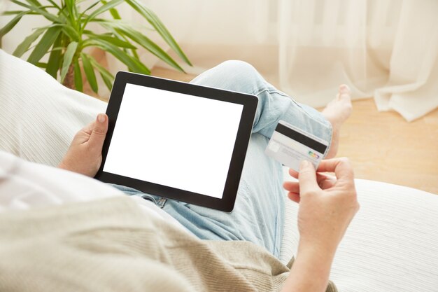 Mulher madura de compras pela Internet online com tablet pc e cartão de crédito