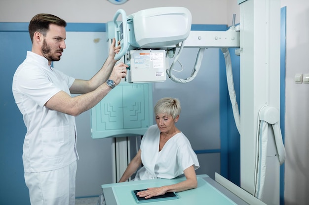 Foto grátis mulher madura e técnico médico durante a varredura de raios x de mão no hospital xaxa