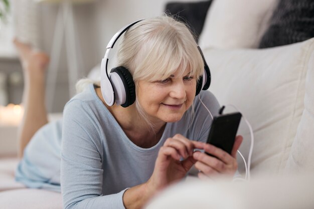 Mulher madura, escolher, música, ligado, smartphone