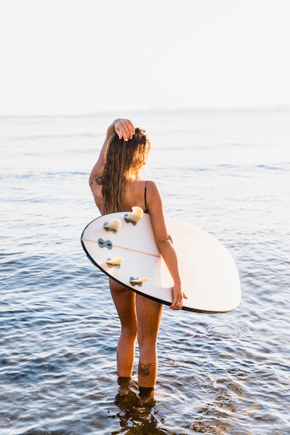 Foto grátis mulher magro com prancha de surf no mar