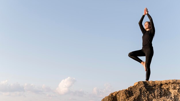 Mulher meditando na costa com espaço de cópia