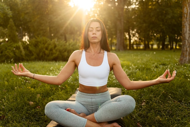 Foto grátis mulher meditando na vista frontal da natureza