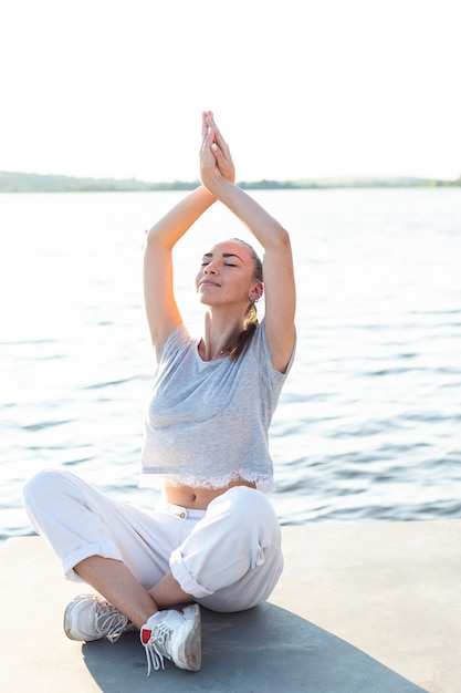 Mulher meditando, perto, água