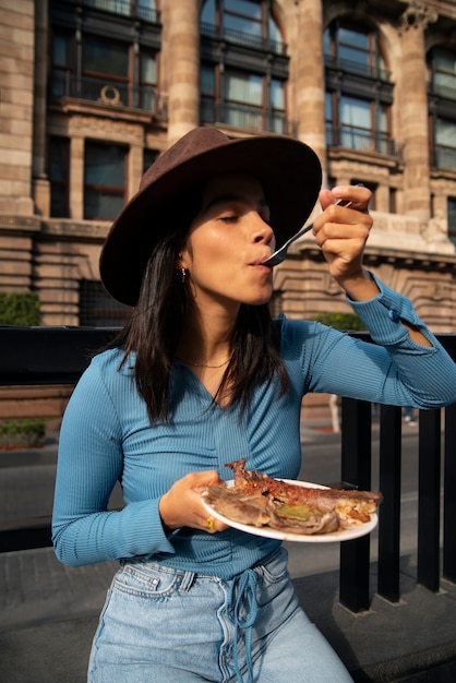 Foto grátis mulher mexicana de tiro médio comendo comida ranchero