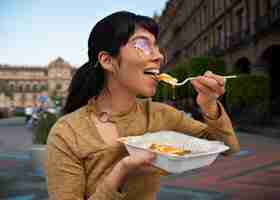 Foto grátis mulher mexicana de tiro médio comendo comida ranchero