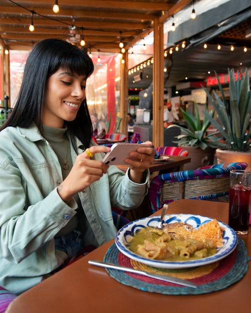 Mulher mexicana de tiro médio comendo comida ranchero