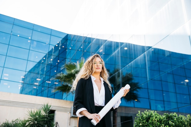 Mulher moderna de negócios em frente ao edifício de vidro