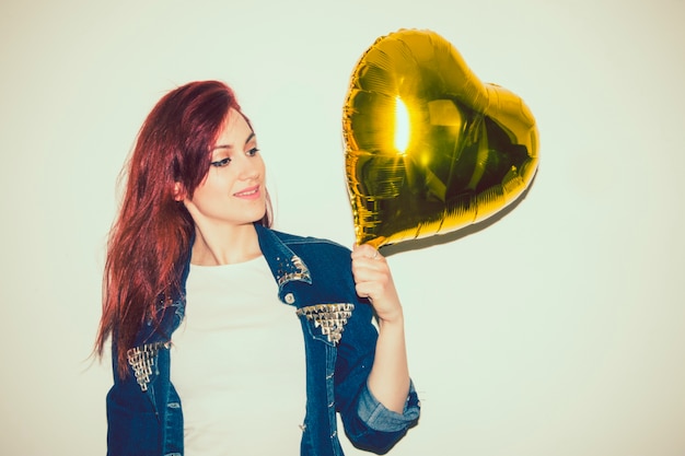 Mulher moderna posando com balão de ouro