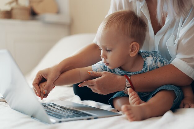 Mulher moderna, trabalhando com criança. Conceito de multitarefa, freelance e maternidade. Fechar-se