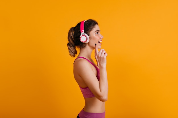 Mulher morena adorável ouvindo música em fones de ouvido