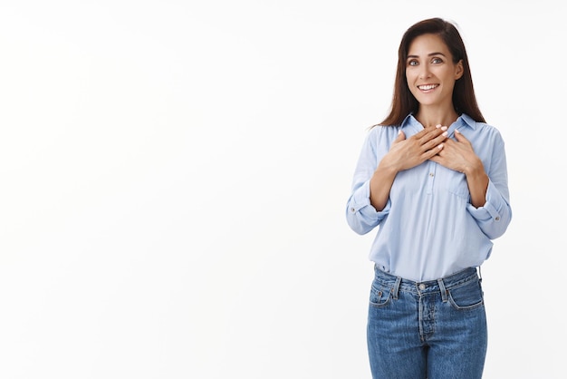 Foto grátis mulher morena caucasiana animada sorrindo feliz aprecie presente agradável toque no peito grato sinta gratidão encantado receba presente suporte fundo branco aceite gesto adorável