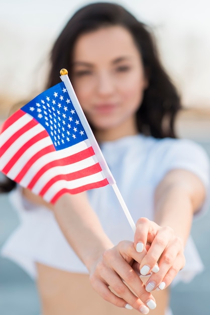 Foto grátis mulher morena close-up, segurando a bandeira dos eua nas mãos