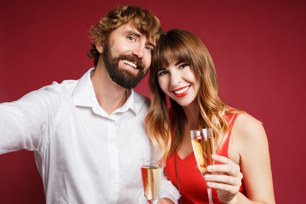 Mulher morena com o marido segurando a taça de champanhe