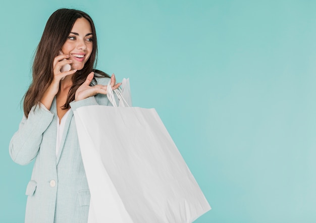 Foto grátis mulher morena com sacos de compras, falando ao telefone