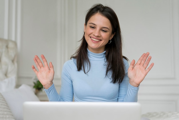 Mulher morena fazendo uma videochamada em casa