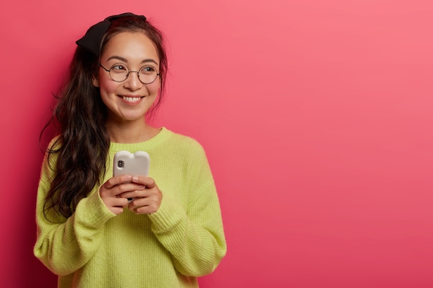 Mulher morena feliz que navega na internet pelo celular e faz compras online