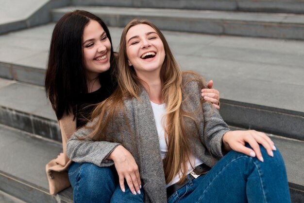 Mulher morena segurando seu amigo sorridente