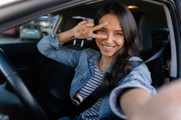 Mulher morena tirando uma selfie no carro