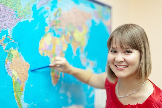 Mulher mostrando algo no mapa do mundo
