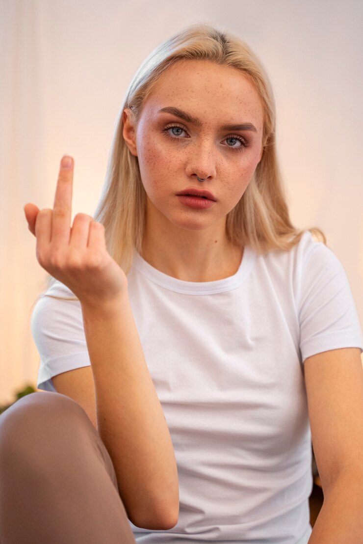 Foto grátis mulher mostrando o dedo médio em casa enquanto malha