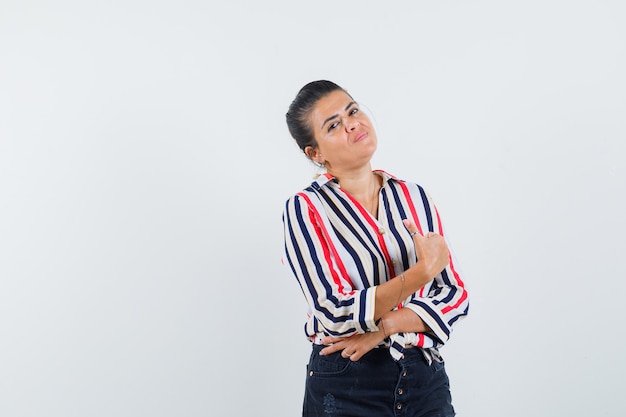 mulher mostrando o polegar para cima na camisa, saia e parecendo satisfeita