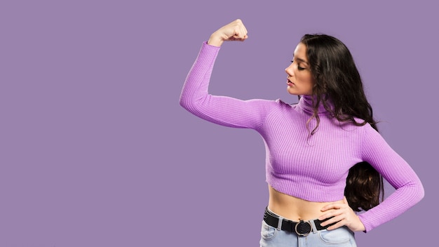 Mulher mostrando os músculos e tendo um top violeta para os lados