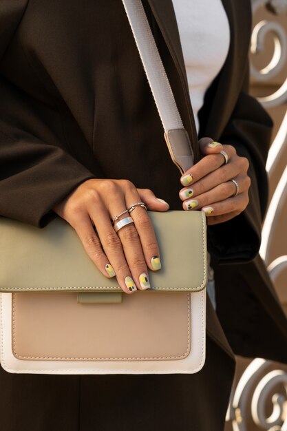 Foto grátis mulher mostrando sua arte do prego nas unhas com bolsa