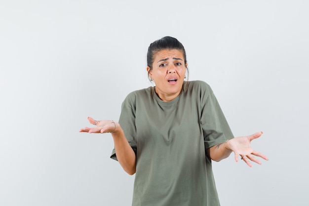 mulher mostrando um gesto desamparado em uma camiseta e parecendo confusa