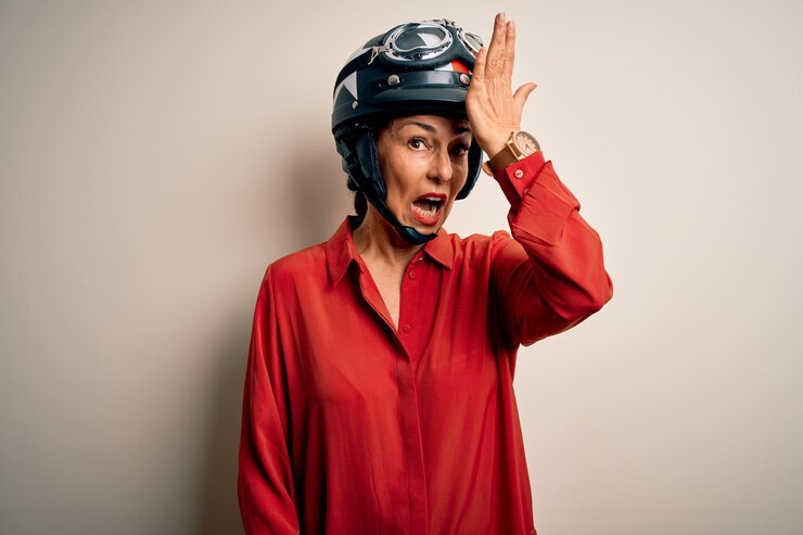 Foto grátis mulher motociclista de meia-idade usando capacete de motocicleta sobre fundo branco isolado surpreendida com a mão na cabeça por erro lembra erro esqueceu conceito de má memória