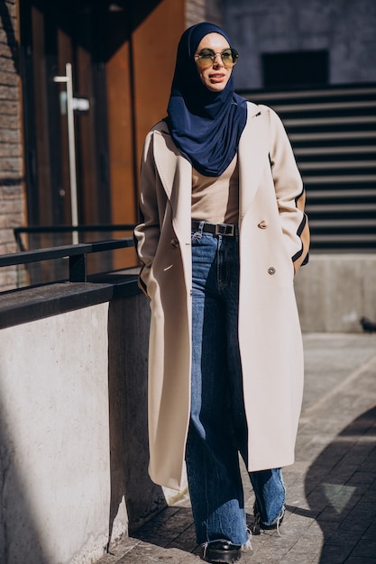 Foto grátis mulher muçulmana moderna com lenço na cabeça, andando na rua