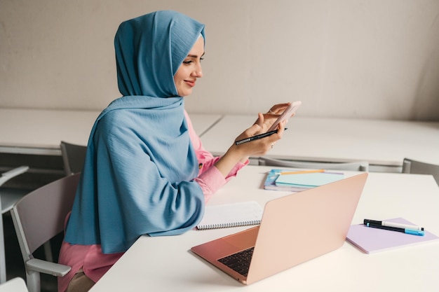 Foto grátis mulher muçulmana moderna em hijab na sala de escritório