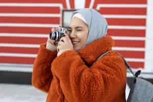 Foto grátis mulher muçulmana tirando uma foto dos arredores enquanto estava de férias
