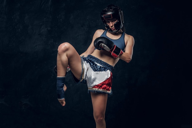 Foto grátis mulher muito forte está demonstrando sua pose de kick boxer enquanto posava para o fotógrafo.