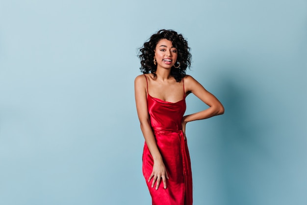 Mulher muito sorridente com vestido vermelho olhando para a frente