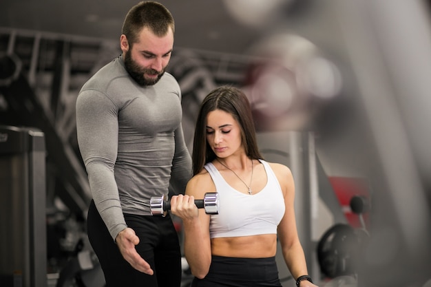 Foto grátis mulher na academia com treinador