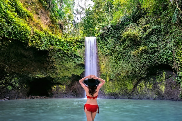 Mulher na cachoeira tibumana na ilha de bali, indonésia