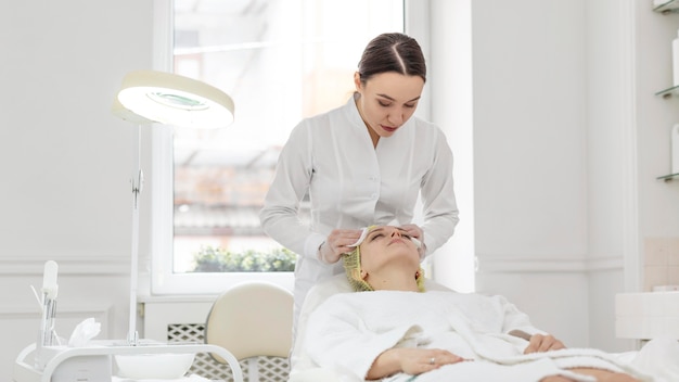 Foto grátis mulher na clínica de beleza para tratamento facial