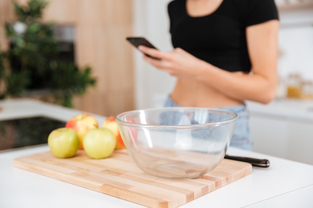 Mulher na cozinha usando o telefone